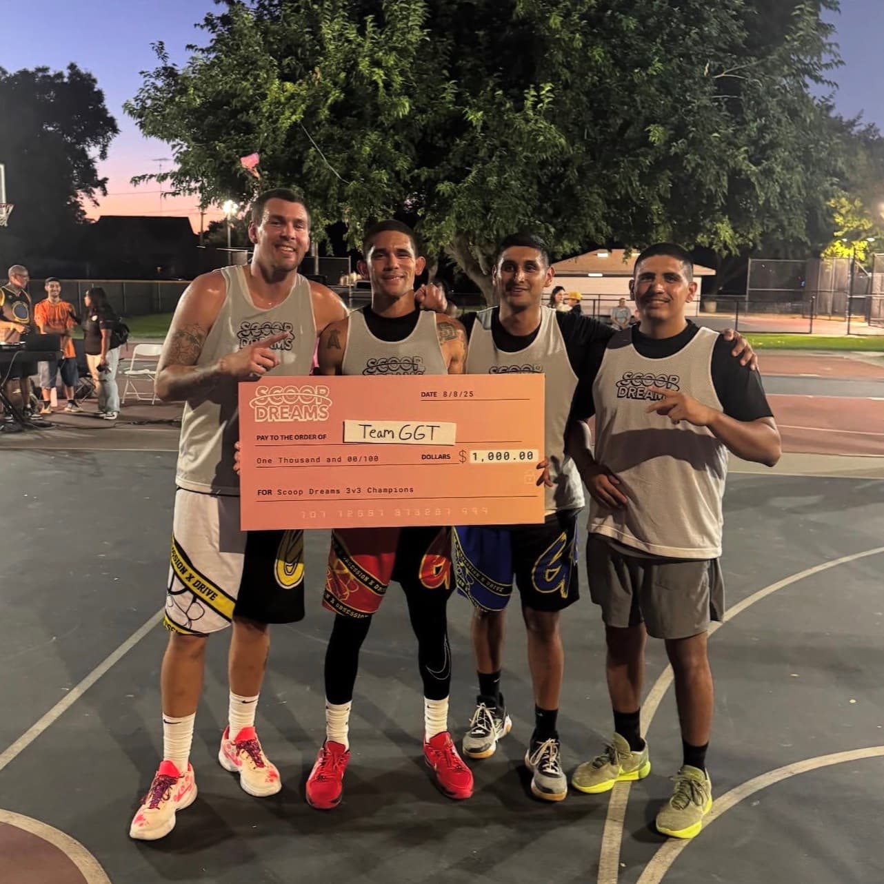 Tournament winning team holding the Scoop Dreams championship check