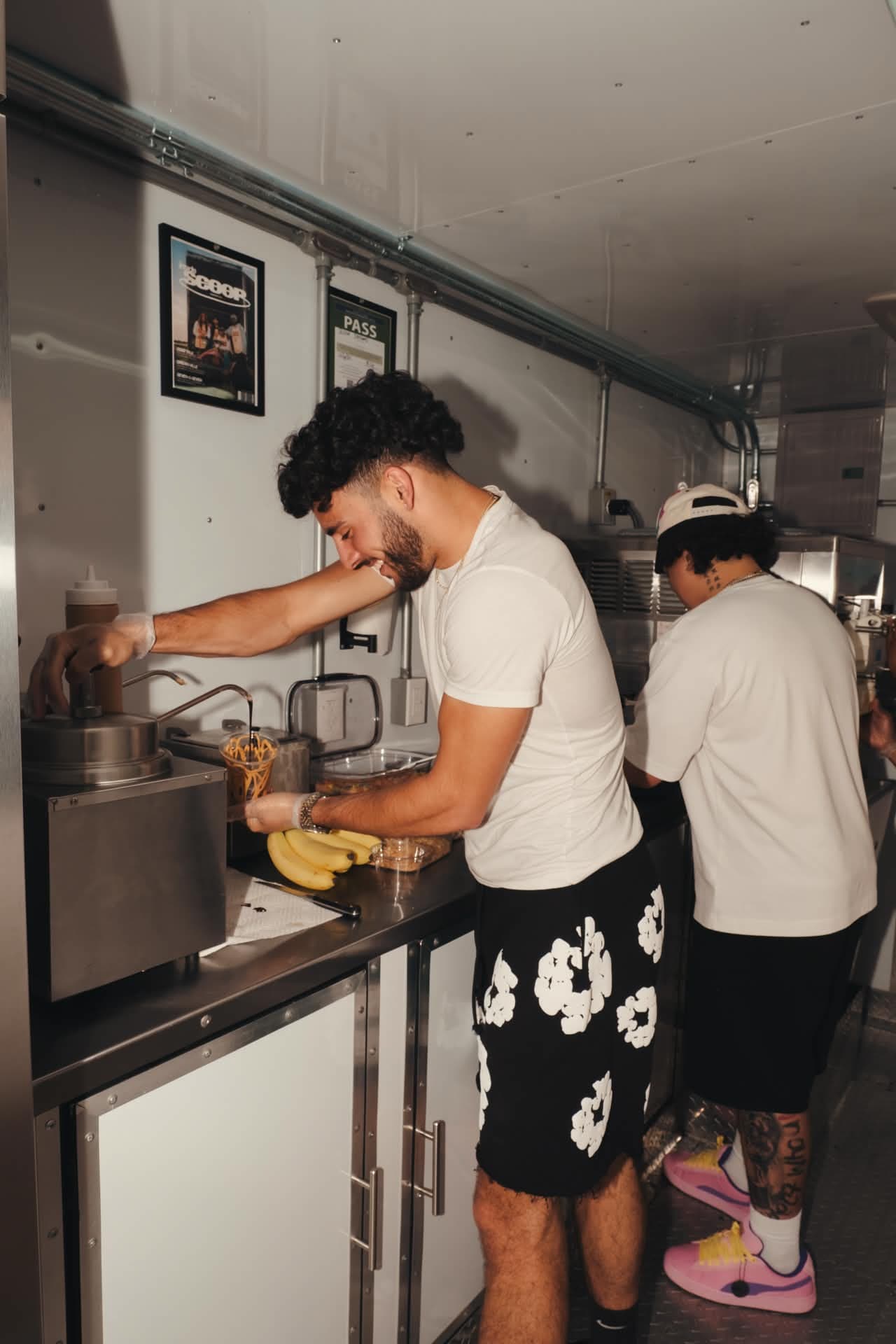 Devan Minouei pulling a vanilla soft serve at the machine inside the Scoop Dreams trailer