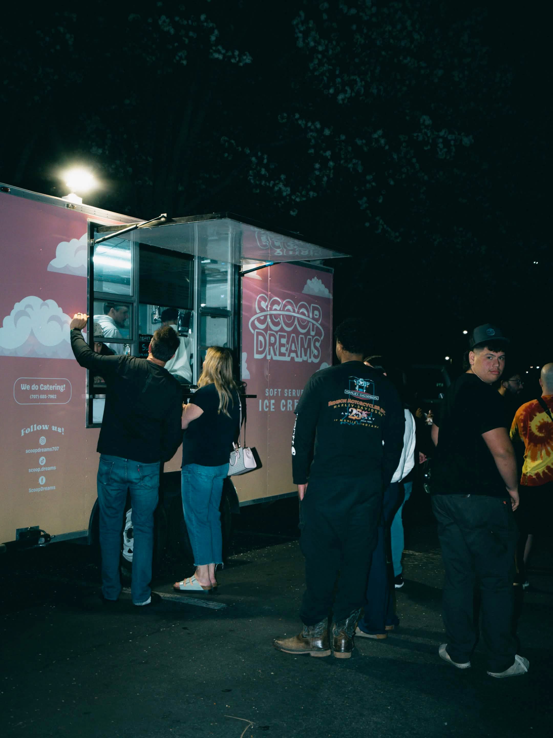 Customers lining up at the side of the Scoop Dreams trailer at night