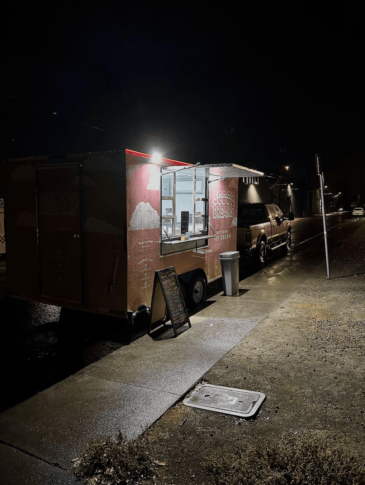 The Scoop Dreams trailer lit up at night serving customers